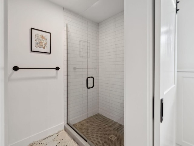 bathroom featuring a shower stall, baseboards, and tile patterned flooring