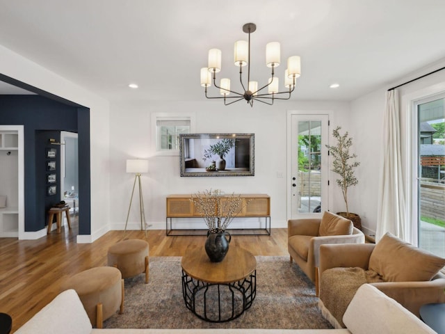 living room with plenty of natural light, a chandelier, wood finished floors, and recessed lighting