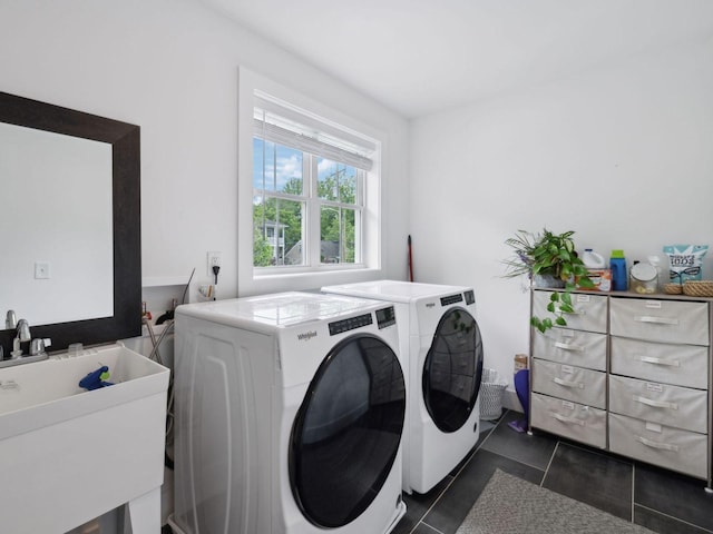 laundry room with independent washer and dryer and dark tile patterned floors