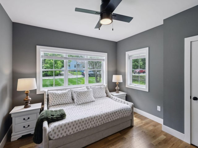 bedroom with baseboards, wood finished floors, and ceiling fan