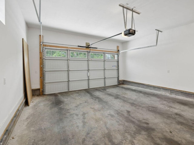 garage with a garage door opener and baseboards