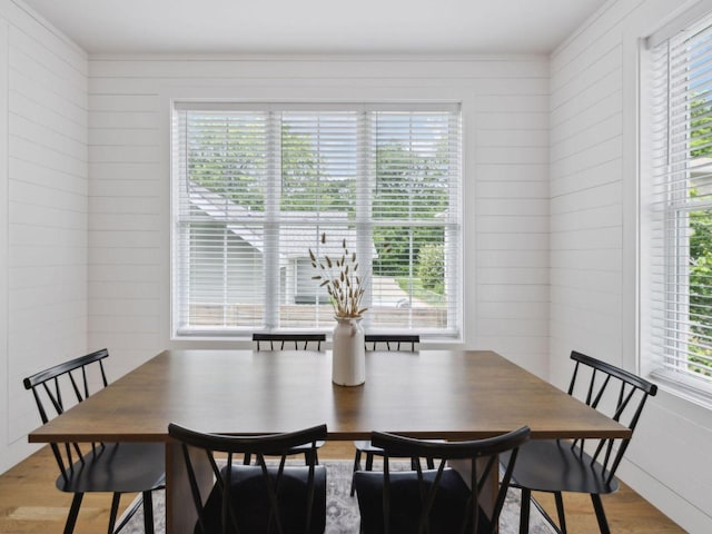 dining space featuring light wood-type flooring and ornamental molding