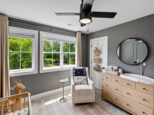 living area with light carpet, ceiling fan, and baseboards