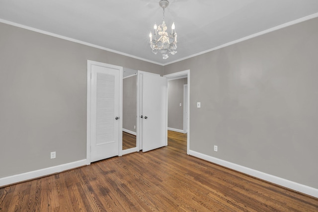 519 S Scott St, Scottsboro, AL 35768 - unfurnished bedroom featuring a chandelier, baseboards, wood finished floors, ornamental molding, and a closet