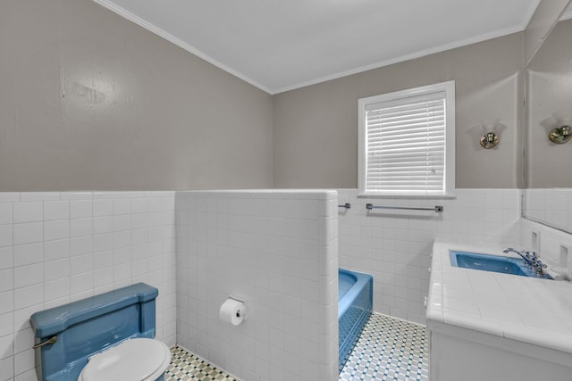 519 S Scott St, Scottsboro, AL 35768 - bathroom featuring tile walls, toilet, a bath, ornamental molding, and wainscoting