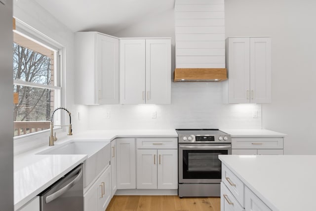 208 Roberta Dr, Hendersonville, TN 37075 - kitchen featuring appliances with stainless steel finishes, vaulted ceiling, light countertops, backsplash, and white cabinetry