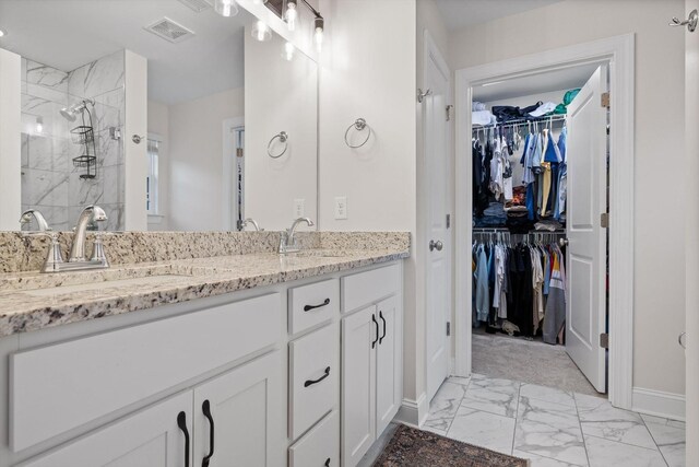3983 Inlet Loop, Chattanooga, TN 37416 - full bath featuring marble look tile flooring, tiled shower, a walk in closet, baseboards, and double vanity