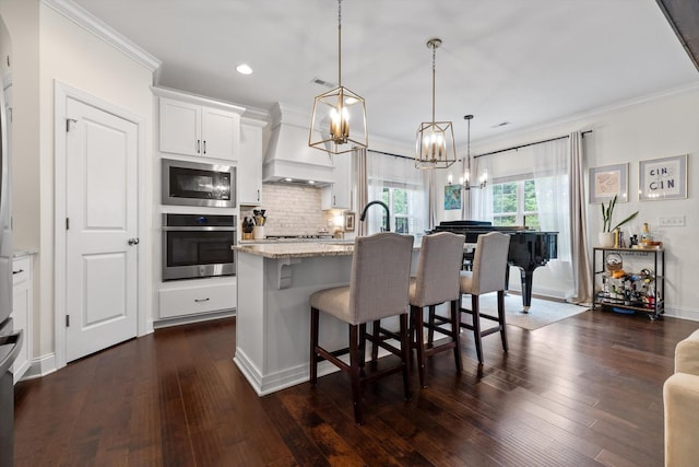 3983 Inlet Loop, Chattanooga, TN 37416 - kitchen featuring appliances with stainless steel finishes, custom range hood, a chandelier, ornamental molding, and a kitchen island with sink