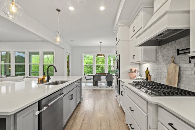 3224 Chase Point Dr, Franklin, TN 37067 - kitchen featuring stainless steel appliances, premium range hood, a sink, backsplash, and light countertops