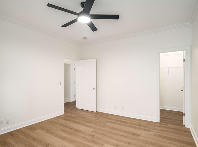 3038 Oxford Glen Dr, Franklin, TN 37067 - unfurnished bedroom with crown molding, light wood-type flooring, a spacious closet, baseboards, and a closet