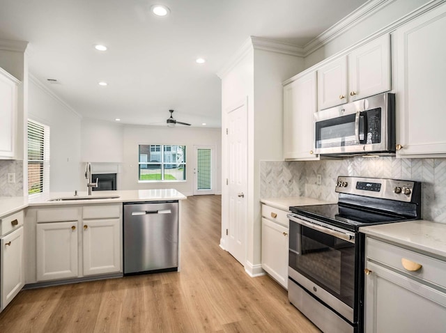 3038 Oxford Glen Dr, Franklin, TN 37067 - kitchen with appliances with stainless steel finishes, a sink, a peninsula, recessed lighting, and crown molding