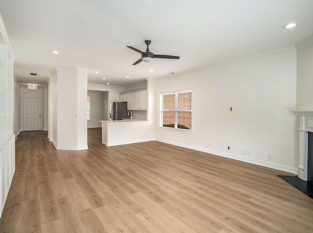 3038 Oxford Glen Dr, Franklin, TN 37067 - unfurnished living room featuring ornamental molding, a ceiling fan, light wood-style flooring, baseboards, and a fireplace with flush hearth