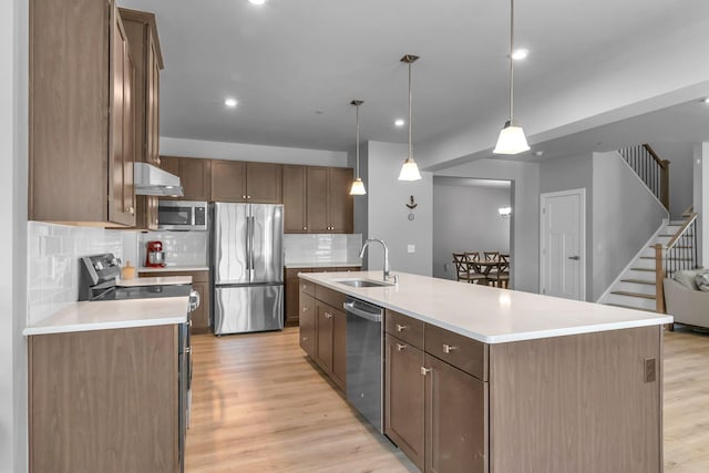 1610 Shenstone Dr, Smyrna, TN 37167 - kitchen featuring appliances with stainless steel finishes, a sink, light wood-type flooring, tasteful backsplash, and light countertops