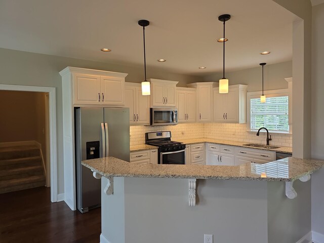 109 Coteswood Ct, Columbia, TN 38401 - kitchen featuring appliances with stainless steel finishes, a sink, dark wood-type flooring, a kitchen bar, and recessed lighting