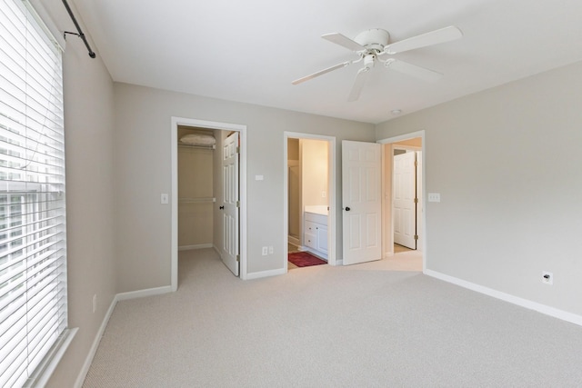 664 Huffine Manor Cir, Franklin, TN 37067 - unfurnished bedroom featuring light carpet, a walk in closet, baseboards, ensuite bathroom, and a ceiling fan
