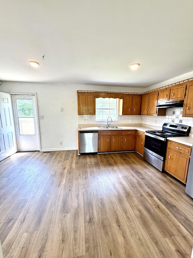 1306 Jared Ct, Clarksville, TN 37042 - kitchen featuring stainless steel appliances, under cabinet range hood, a sink, brown cabinetry, and plenty of natural light