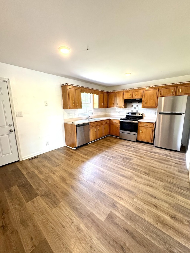 1306 Jared Ct, Clarksville, TN 37042 - kitchen with stainless steel appliances, a sink, light countertops, and brown cabinetry