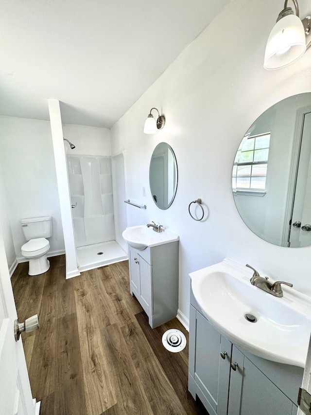 1306 Jared Ct, Clarksville, TN 37042 - full bathroom with walk in shower, toilet, wood finished floors, two vanities, and baseboards
