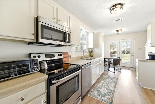 1518 Saint Andrews Dr, Murfreesboro, TN 37128 - kitchen featuring stainless steel appliances, a sink, a textured ceiling, light wood-style floors, and light countertops