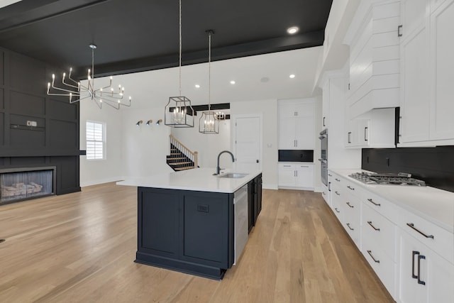 5735 Willoughby Way, Murfreesboro, TN 37129 - kitchen featuring a sink, a chandelier, stainless steel appliances, light wood-style floors, and white cabinetry