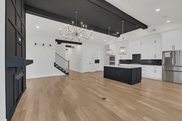 5735 Willoughby Way, Murfreesboro, TN 37129 - kitchen with appliances with stainless steel finishes, a chandelier, tasteful backsplash, white cabinets, and light countertops