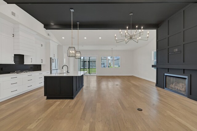 5735 Willoughby Way, Murfreesboro, TN 37129 - kitchen with a chandelier, a sink, light countertops, stainless steel refrigerator, and white cabinetry