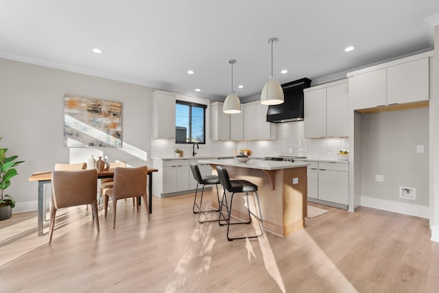 725 N Highland Ave, Murfreesboro, TN 37130 - kitchen featuring custom exhaust hood, a breakfast bar area, a center island, tasteful backsplash, and light countertops