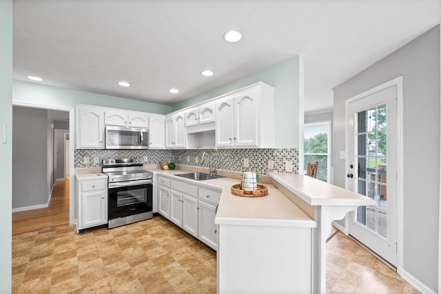 3659 Fieldstone Dr, Clarksville, TN 37040 - kitchen with stainless steel appliances, a sink, a peninsula, light flooring, and decorative backsplash
