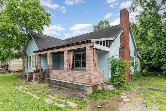 104 Lowe St, Ashland City, TN 37015 - view of side of home with a porch, roof with shingles, a chimney, and a yard