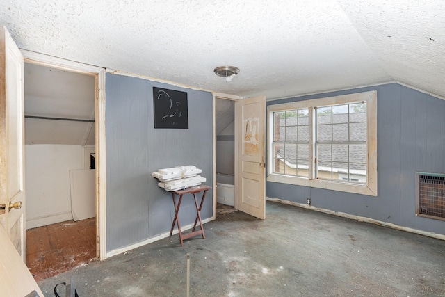 104 Lowe St, Ashland City, TN 37015 - unfurnished bedroom with heating unit, a textured ceiling, vaulted ceiling, baseboards, and wooden walls