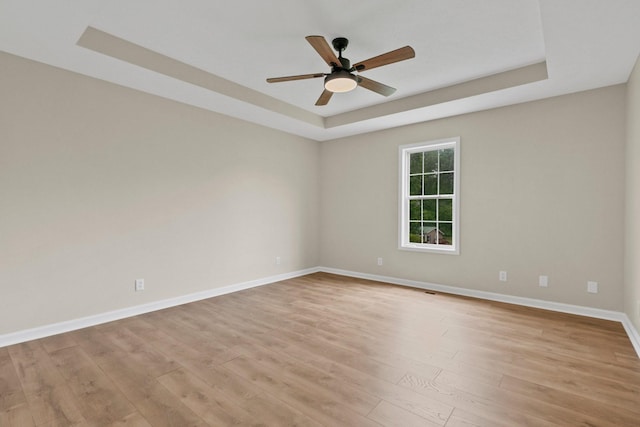 876 Oliver St, Scottsville, KY 42164 - empty room with a tray ceiling, a ceiling fan, light wood-style floors, and baseboards