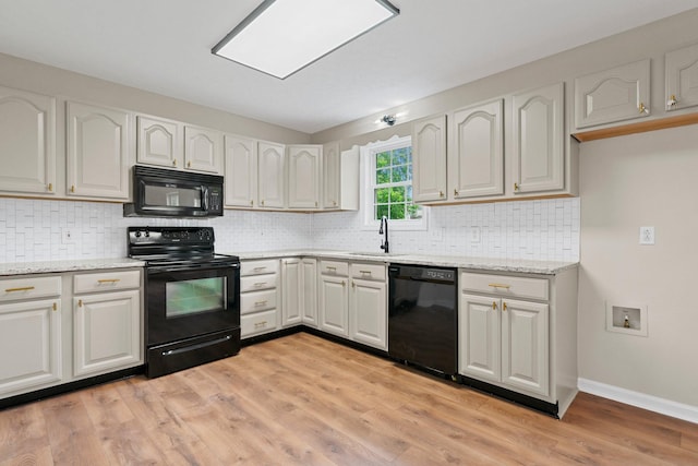 876 Oliver St, Scottsville, KY 42164 - kitchen with black appliances, a sink, light stone countertops, light wood-style floors, and tasteful backsplash