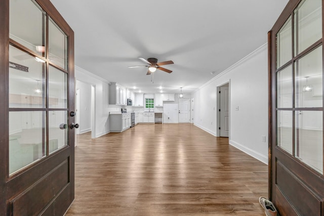 101 Henry Thompson Rd, Taft, TN 38488 - unfurnished living room featuring crown molding, wood finished floors, ceiling fan, and baseboards