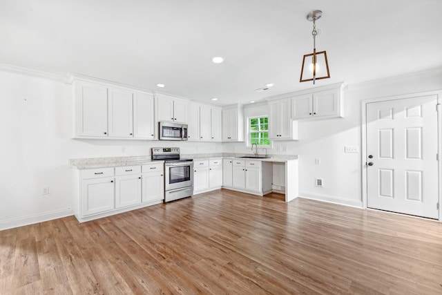 101 Henry Thompson Rd, Taft, TN 38488 - kitchen featuring stainless steel appliances, a sink, baseboards, light wood finished floors, and white cabinets