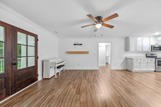 101 Henry Thompson Rd, Taft, TN 38488 - unfurnished living room featuring light wood-style flooring, baseboards, ornamental molding, a ceiling fan, and french doors