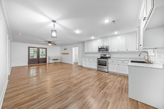 101 Henry Thompson Rd, Taft, TN 38488 - kitchen with stainless steel appliances, a sink, ceiling fan, open floor plan, and light wood finished floors