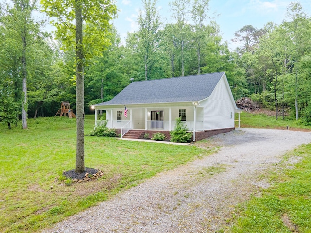 101 Henry Thompson Rd, Taft, TN 38488 - view of front of house with a porch, driveway, a front yard, and a shingled roof