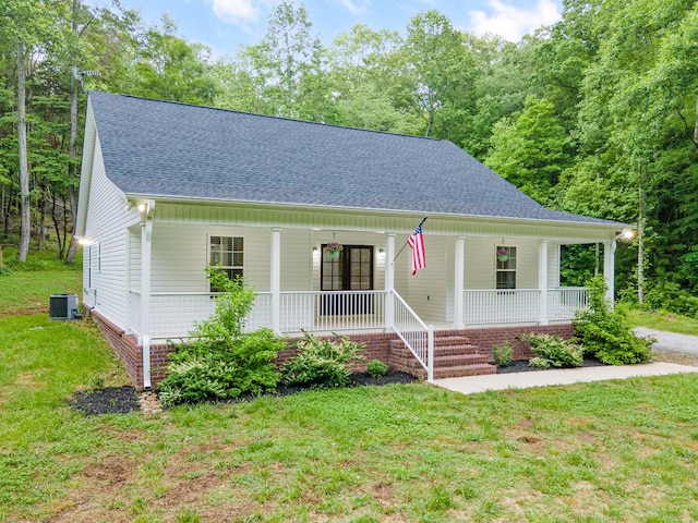 101 Henry Thompson Rd, Taft, TN 38488 - view of front facade with a porch, a shingled roof, a front lawn, and central AC unit
