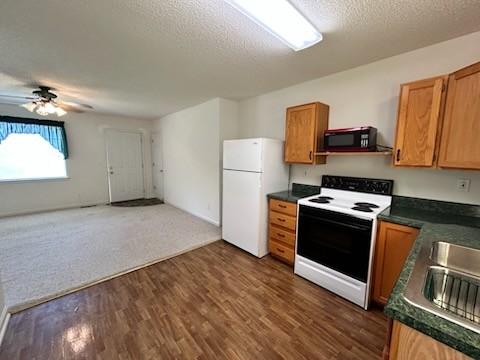 1368 Pleasant Hill Rd, Lynchburg, TN 37352 - kitchen with range with electric stovetop, freestanding refrigerator, black microwave, dark countertops, and a ceiling fan