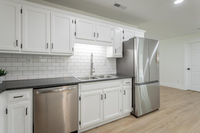 9039 Dallas Hollow Rd, Soddy Daisy, TN 37379 - kitchen featuring appliances with stainless steel finishes, a sink, dark countertops, light wood-style flooring, and recessed lighting