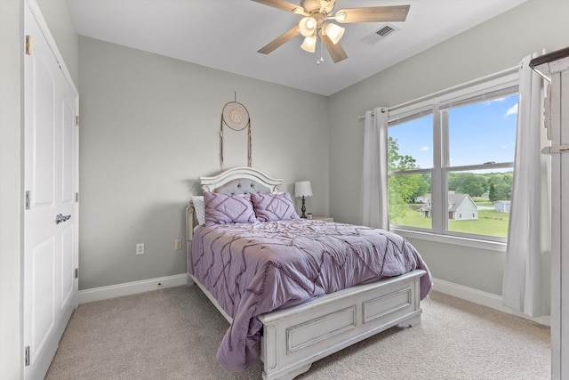 bedroom with light carpet, baseboards, and a ceiling fan