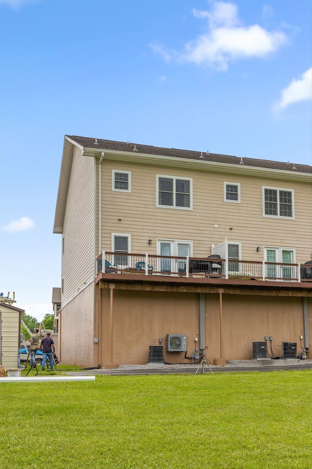 back of property with a yard, cooling unit, a wooden deck, and a cooling unit