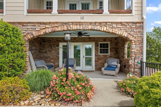 property entrance with a ceiling fan and stone siding