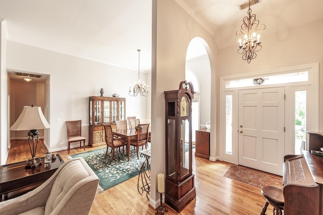 6737 Autumnwood Dr, Nashville, TN 37221 - entrance foyer featuring a chandelier, arched walkways, light wood-style floors, ornamental molding, and baseboards