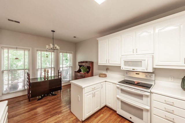 6737 Autumnwood Dr, Nashville, TN 37221 - kitchen with white appliances, a chandelier, light wood-style floors, a peninsula, and white cabinetry