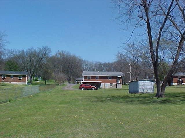view of grassy yard featuring an outbuilding and a storage shed