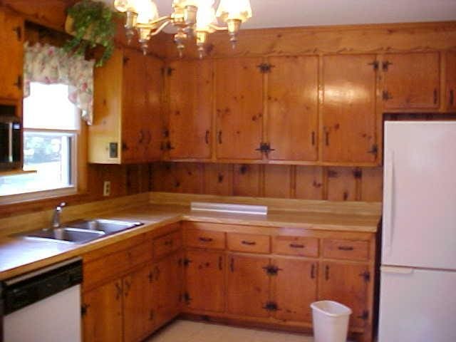 kitchen with white appliances, a sink, a chandelier, and light countertops