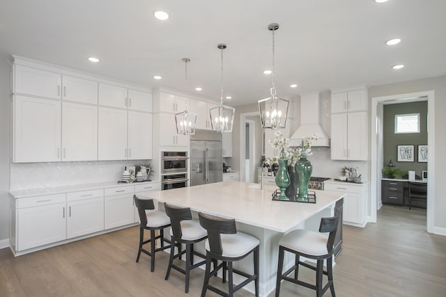 5969 Hunt Valley Dr, Spring Hill, TN 37174 - kitchen with appliances with stainless steel finishes, custom exhaust hood, tasteful backsplash, light wood finished floors, and recessed lighting