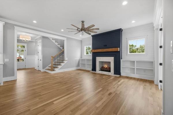 1941 Harmony Rd, Spring Hill, TN 37174 - unfurnished living room with stairs, light wood-style floors, recessed lighting, a fireplace, and plenty of natural light