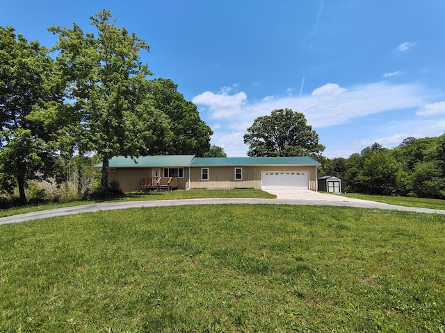 view of front of house with driveway, a shed, a front lawn, and a garage